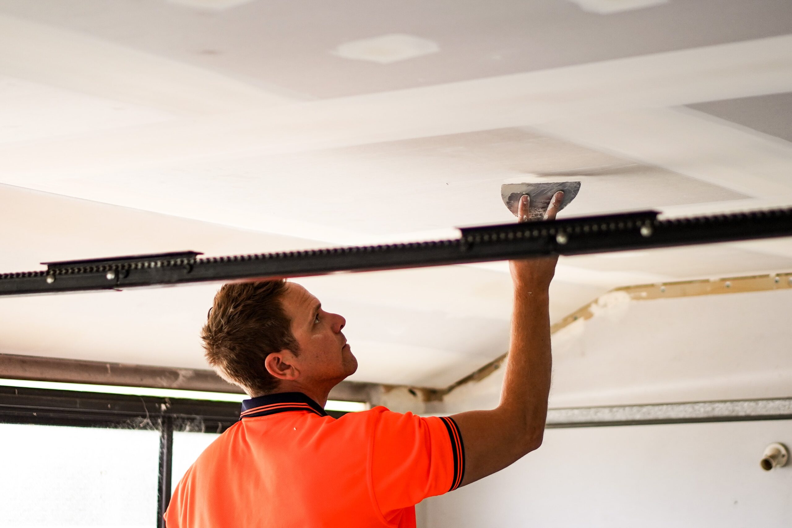 AR Plus team member plastering a garage ceiling in New Zealand