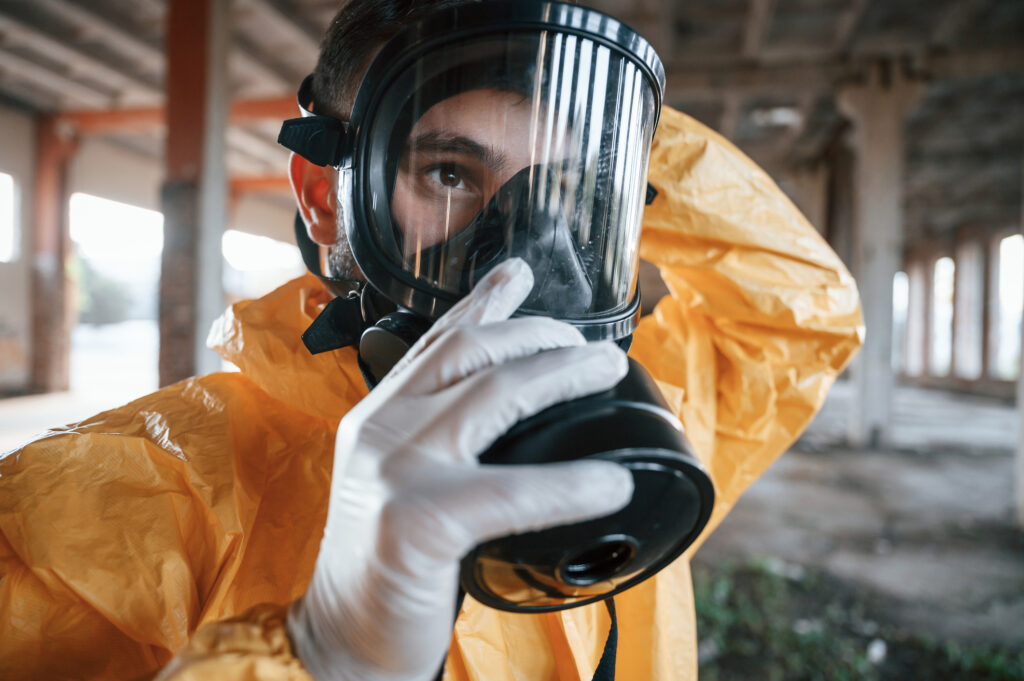 Man dressed in PPE, wearing gloves and respirator in preparation for asbestos removal NZ.